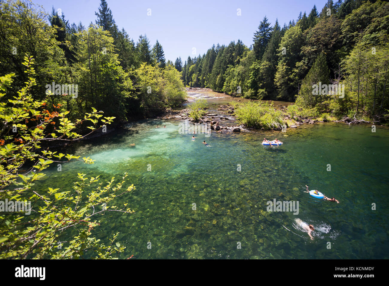 Chi cerca il sole e chi nuota si sposta a Barbers Hole lungo il fiume Oyster, una popolare area per nuotare nella Comox Valley. Isola di Vancouver Foto Stock