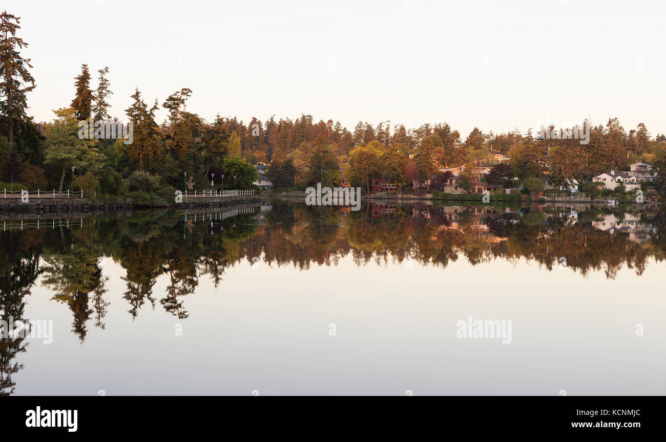Alloggiamento lungo la gola di victoria si riflette nelle sue acque riflettenti di sunrise, victoria, isola di Vancouver, British Columbia, Canada Foto Stock