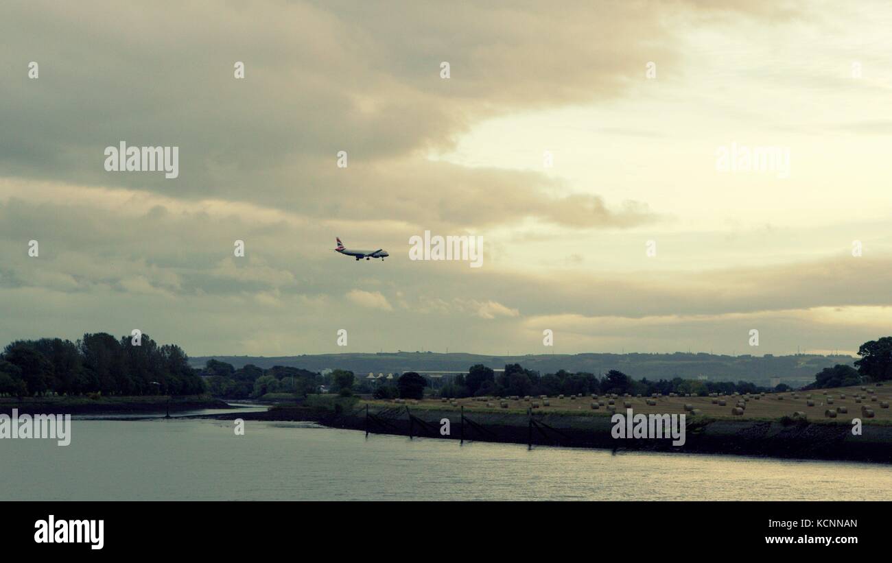 Approcci aerei Aeroporto di Glasgow inizio crepuscolo serale su balle di fieno e campi in corrispondenza della giunzione di black Carrello acqua e fiume Clyde clydebank Foto Stock