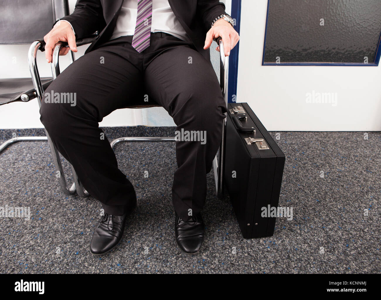 Primo piano dell'uomo in attesa per il colloquio di lavoro seduti su una sedia Foto Stock
