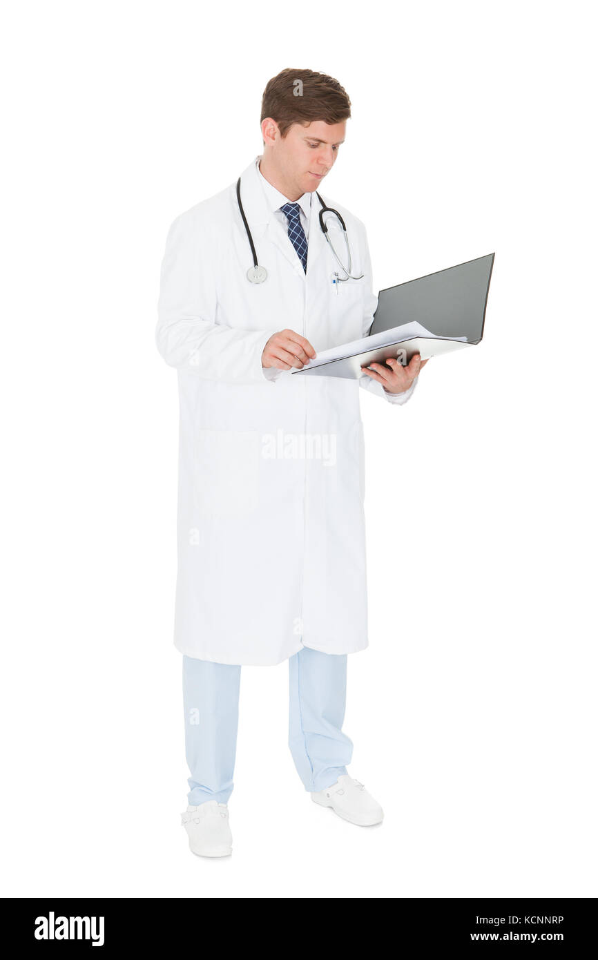 Giovane maschio medico i record di controllo su sfondo bianco Foto Stock