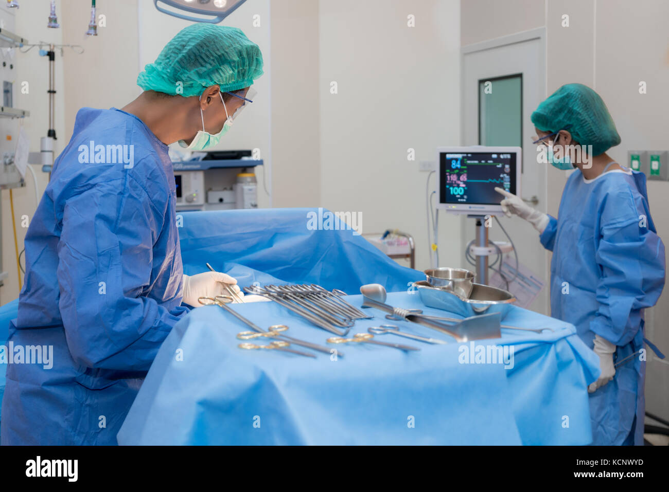Asian medico e un assistente in sala operatoria per chirurgia vascolare venosa clinica di chirurgia in ospedale. Foto Stock