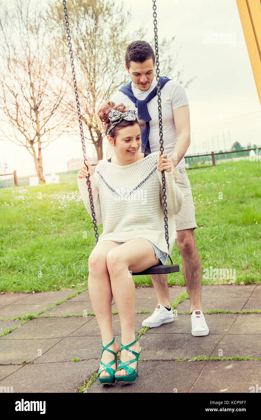 Giovane uomo spinge la sua fidanzata sull'altalena all' aperto nel parco  Foto stock - Alamy