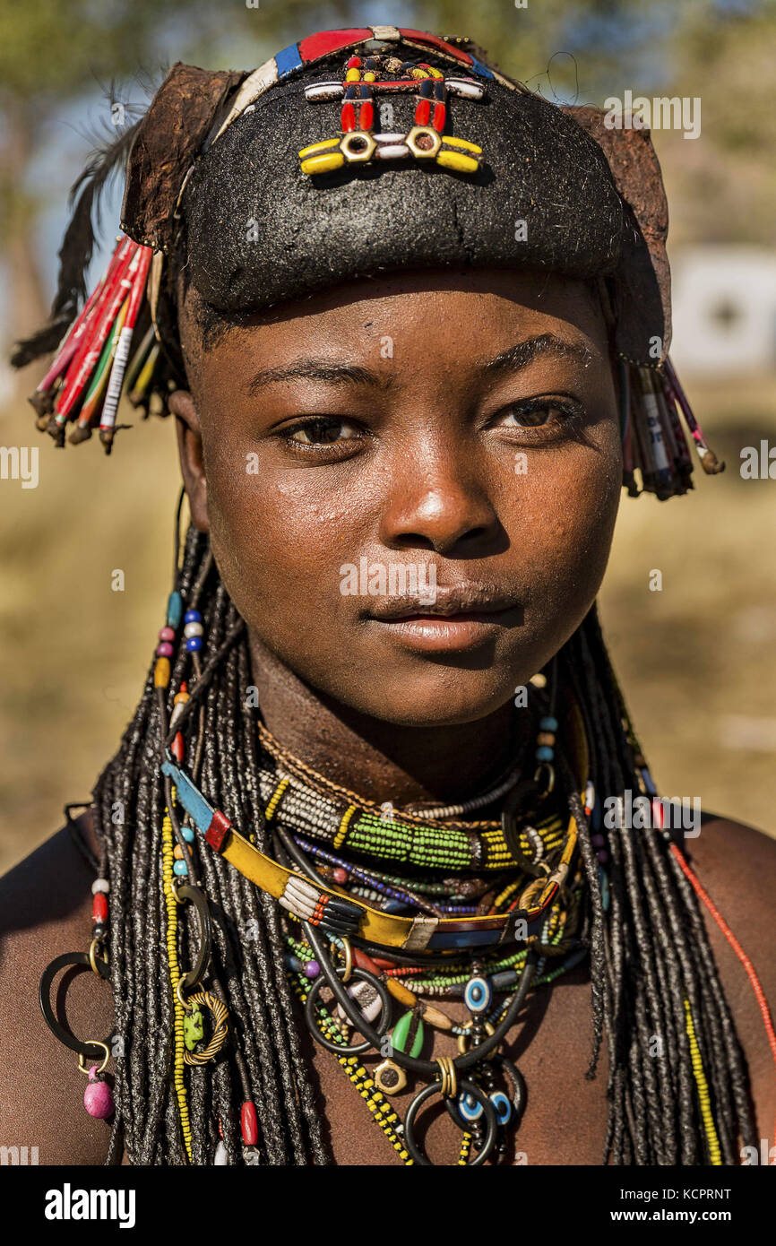 Angola. 23 luglio 2016. La giovane Muhacaona/Mucawana girl. Le donne di Mucawana, proprio come il popolo Himba, sono molto alla moda a loro volta. Fanno i pettinature decorativi e adornano il loro corpo con ornamenti. La pettinatura femminile è fatta con un mix di sterco di vacca, grasso, e erbe per la fragranza. Le Mukawanas rimuovono i loro denti inferiori, il che viene fatto colpendoli con una pietra. Occupano una terra meridionale, isolata dal resto del paese da deserti e montagne, e hanno mantenuto la loro individualità etnica e la cultura Credit: Tariq Zaidi/ZUMA Wire/Alamy Live News Foto Stock