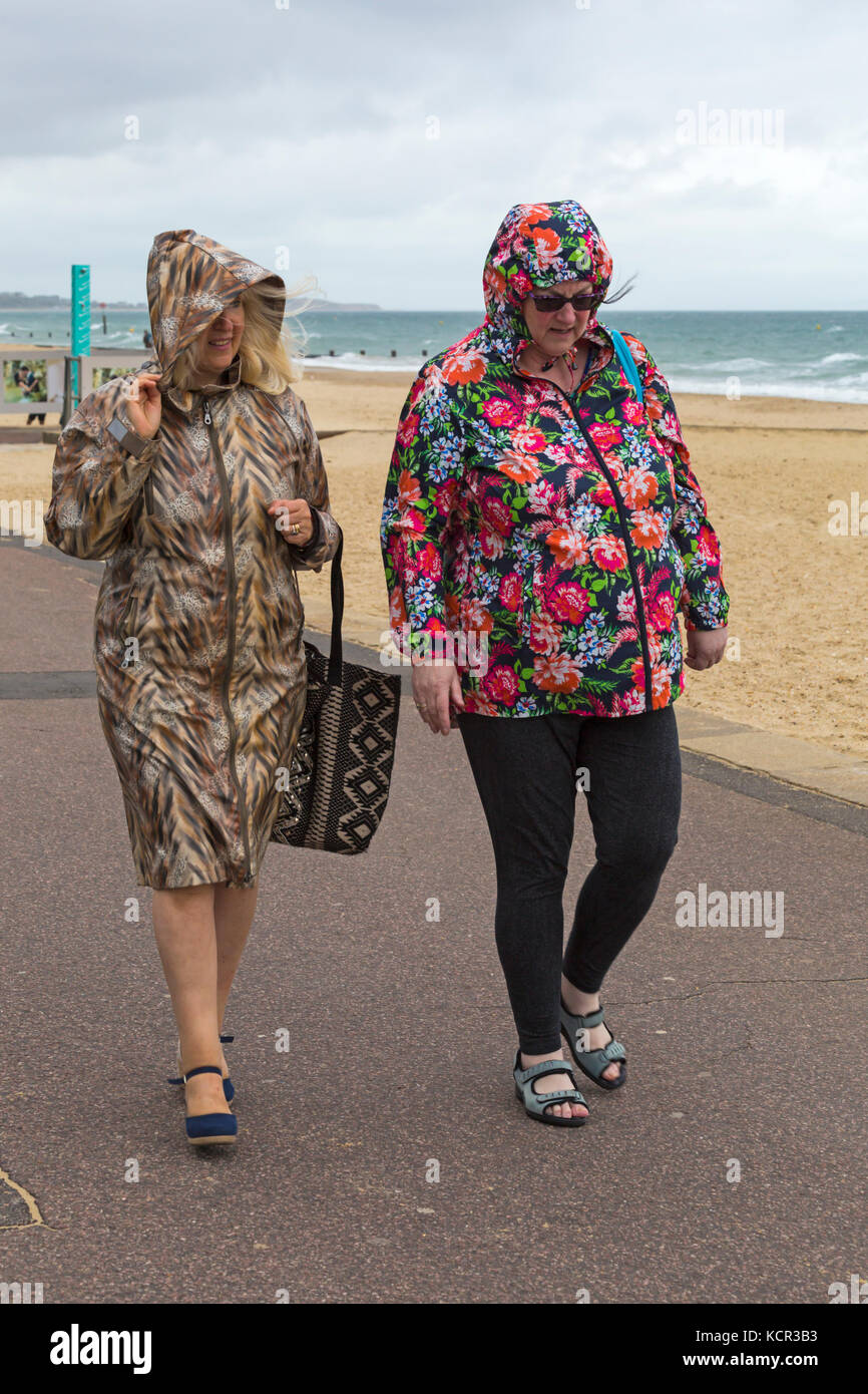 Bournemouth Dorset, Regno Unito. Il 7 ottobre, 2017. Regno Unito: meteo ariosi e coperto a Bournemouth Beach con qualche pioggerella, come due donne a piedi lungo la passeggiata lungomare di rivestimenti colorati con calotte fino. Credito: Carolyn Jenkins/Alamy Live News Foto Stock