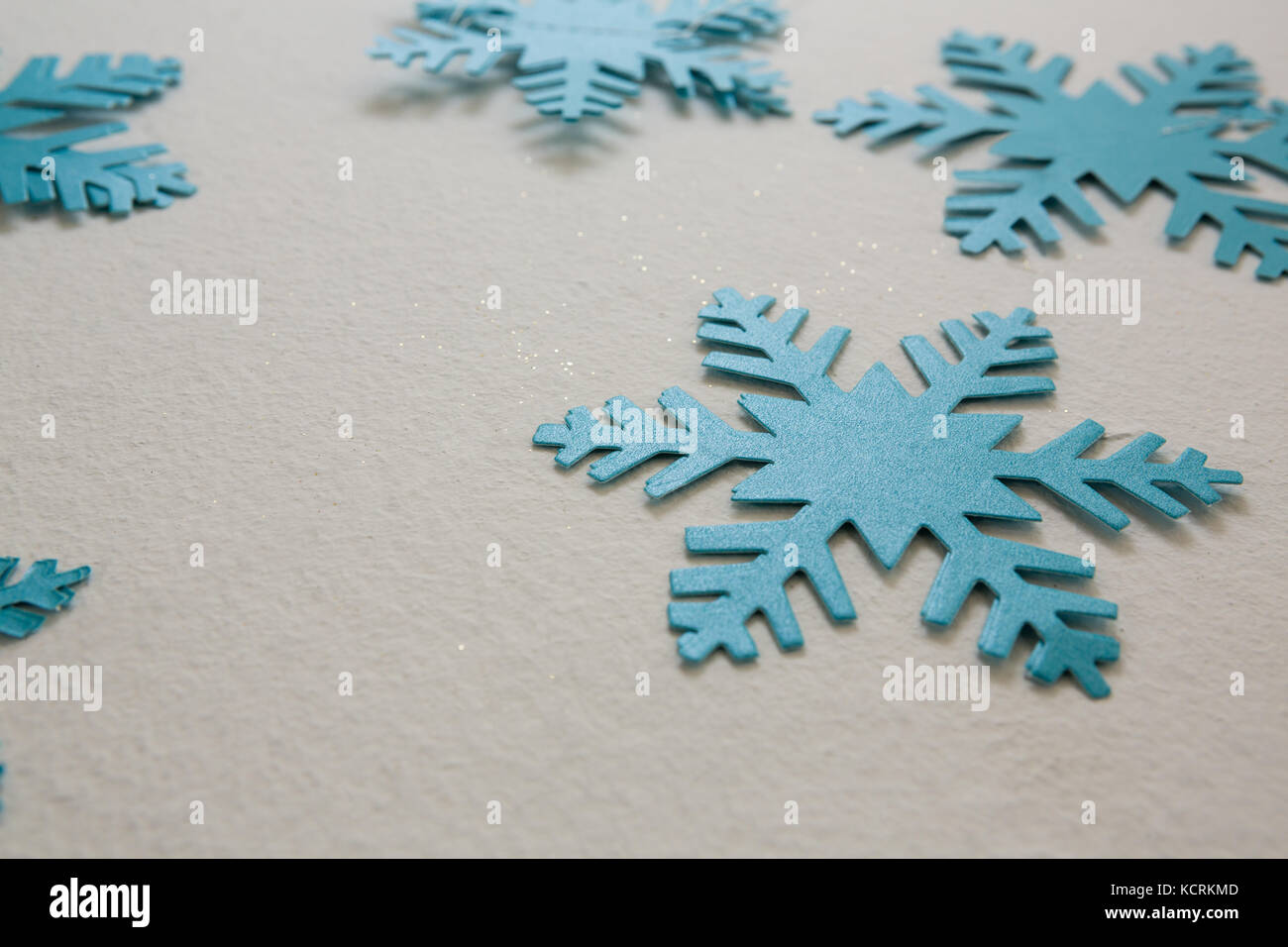 Close-up di fiocchi di neve in blu su sfondo bianco Foto Stock