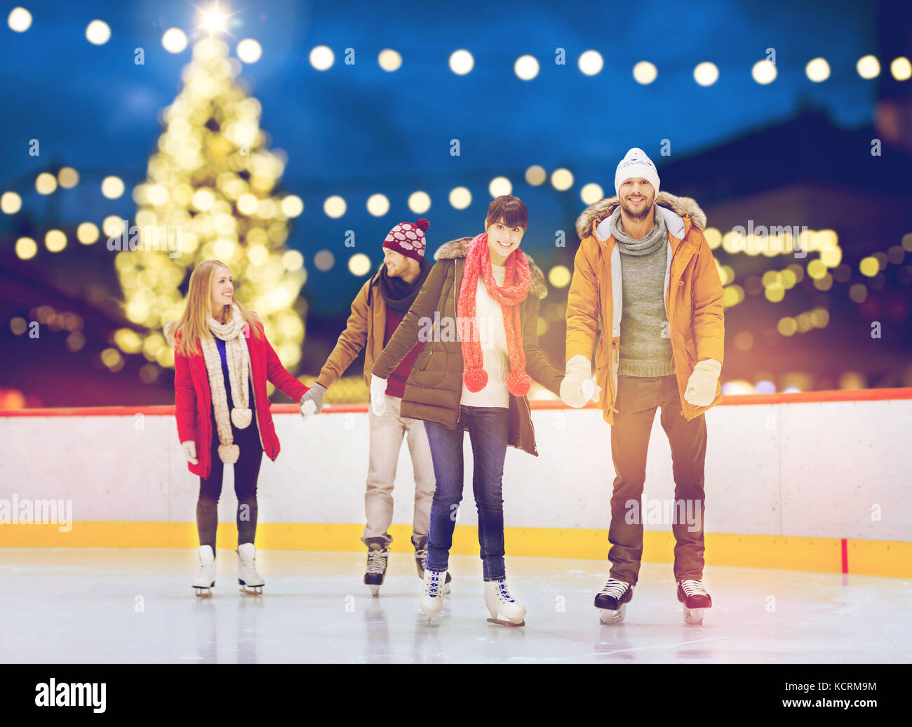 Happy amici sul Natale pista di pattinaggio Foto Stock