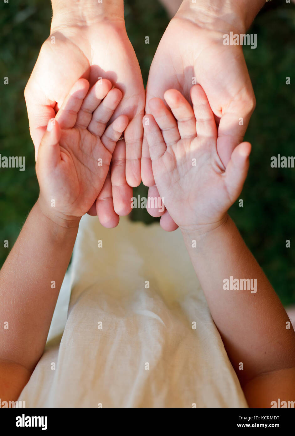 Bambina che mostra le sue mani di madre all'aperto Foto Stock