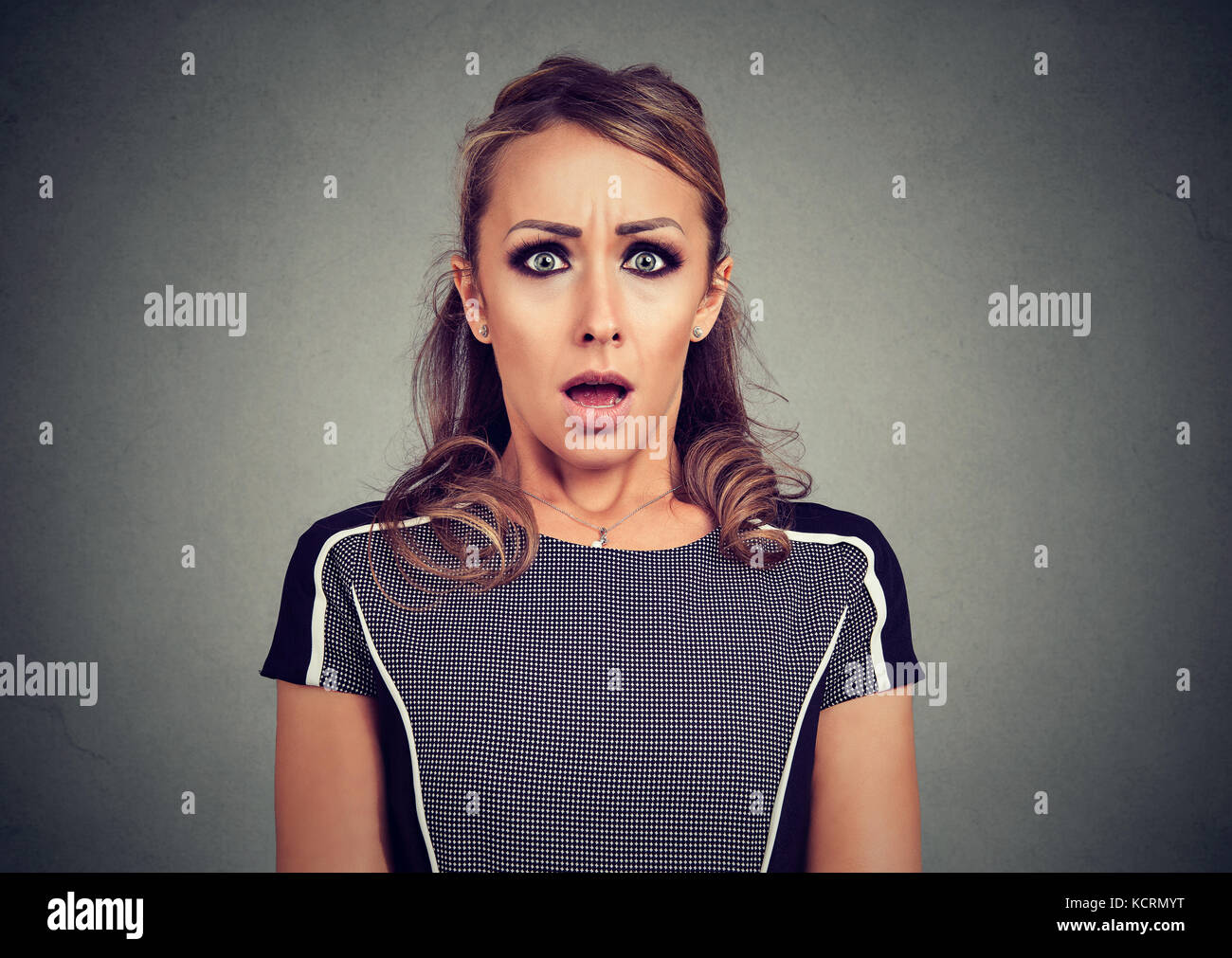 Spaventata scioccato donna isolato su sfondo grigio Foto Stock