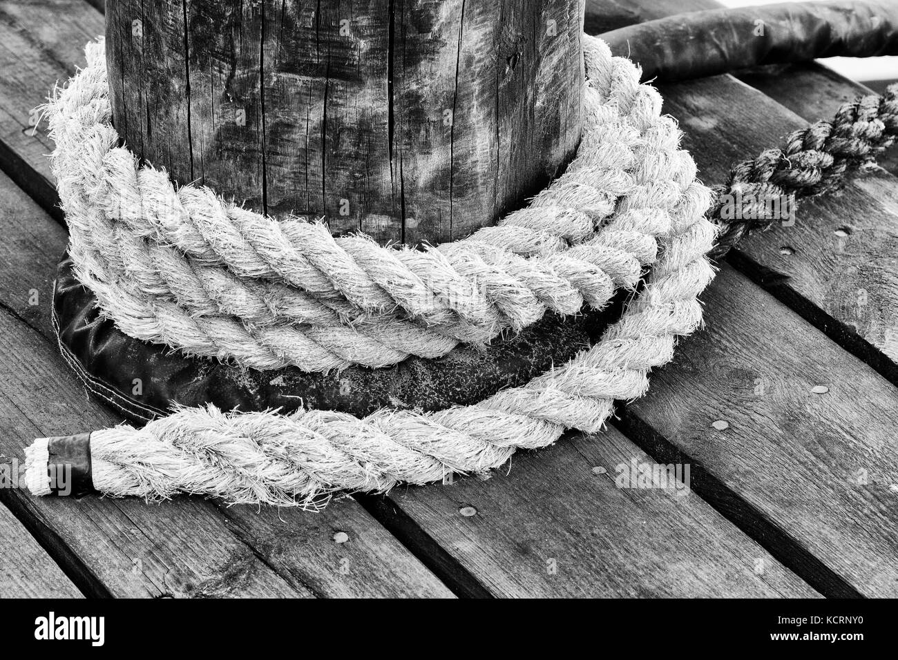 In bianco e nero di fune avvolta intorno al molo di dock post. vista dall'alto. Foto Stock