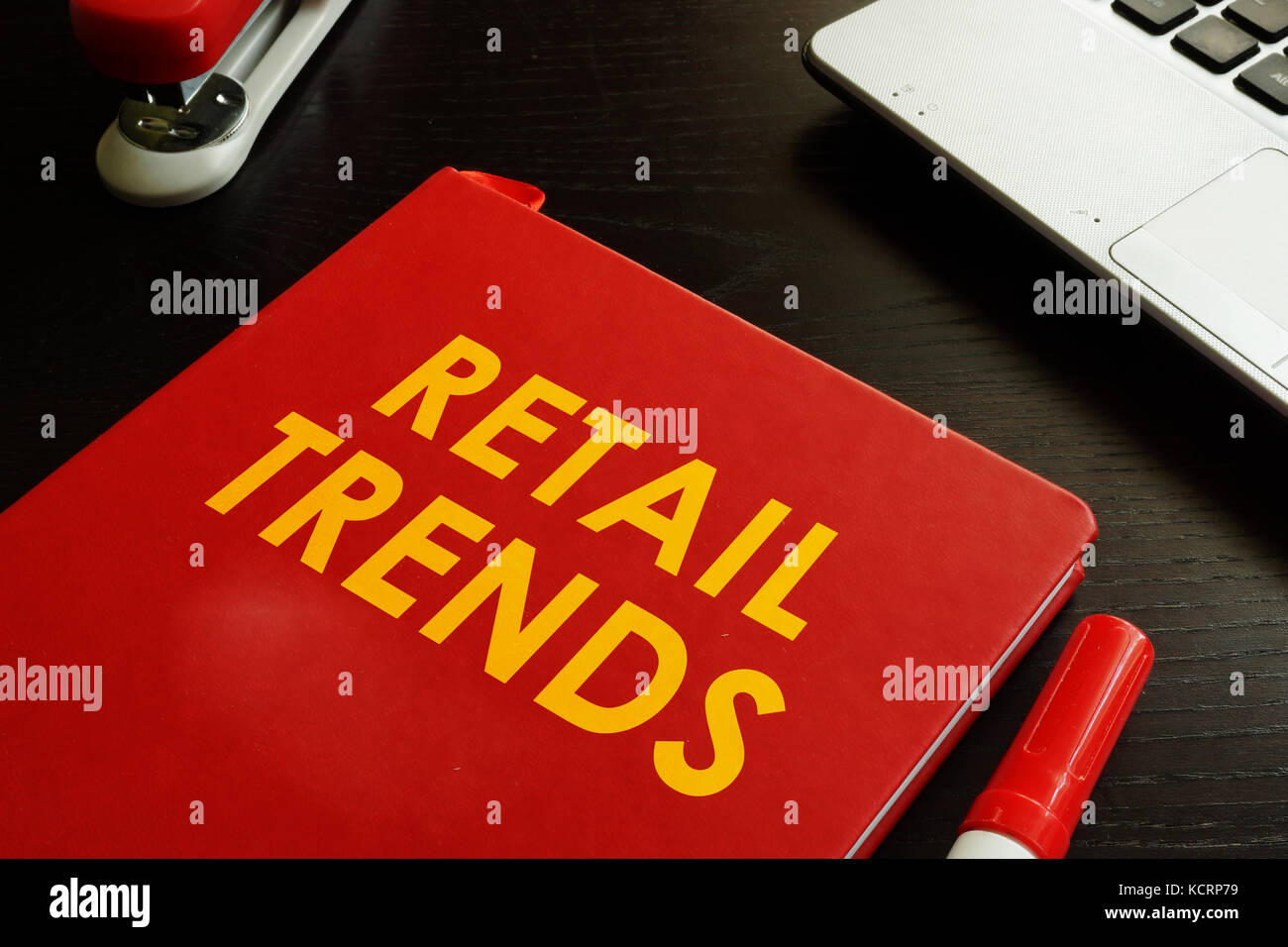Prenota con titolo tendenze di vendita al dettaglio su una scrivania. Foto Stock