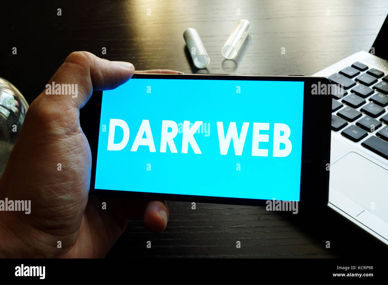 Uomo con smart phone con dark web. Foto Stock