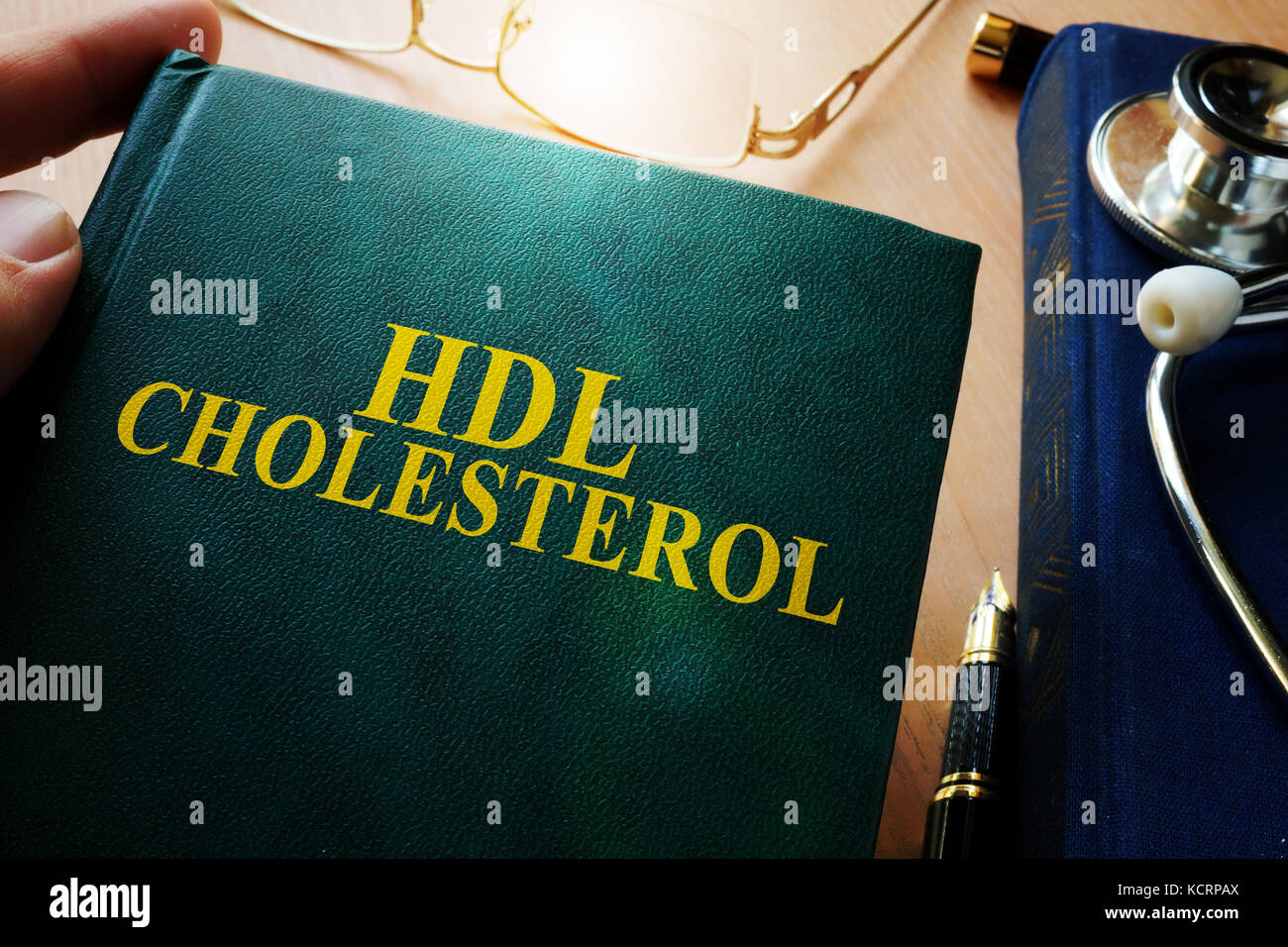L'uomo azienda prenota circa il colesterolo HDL. Foto Stock