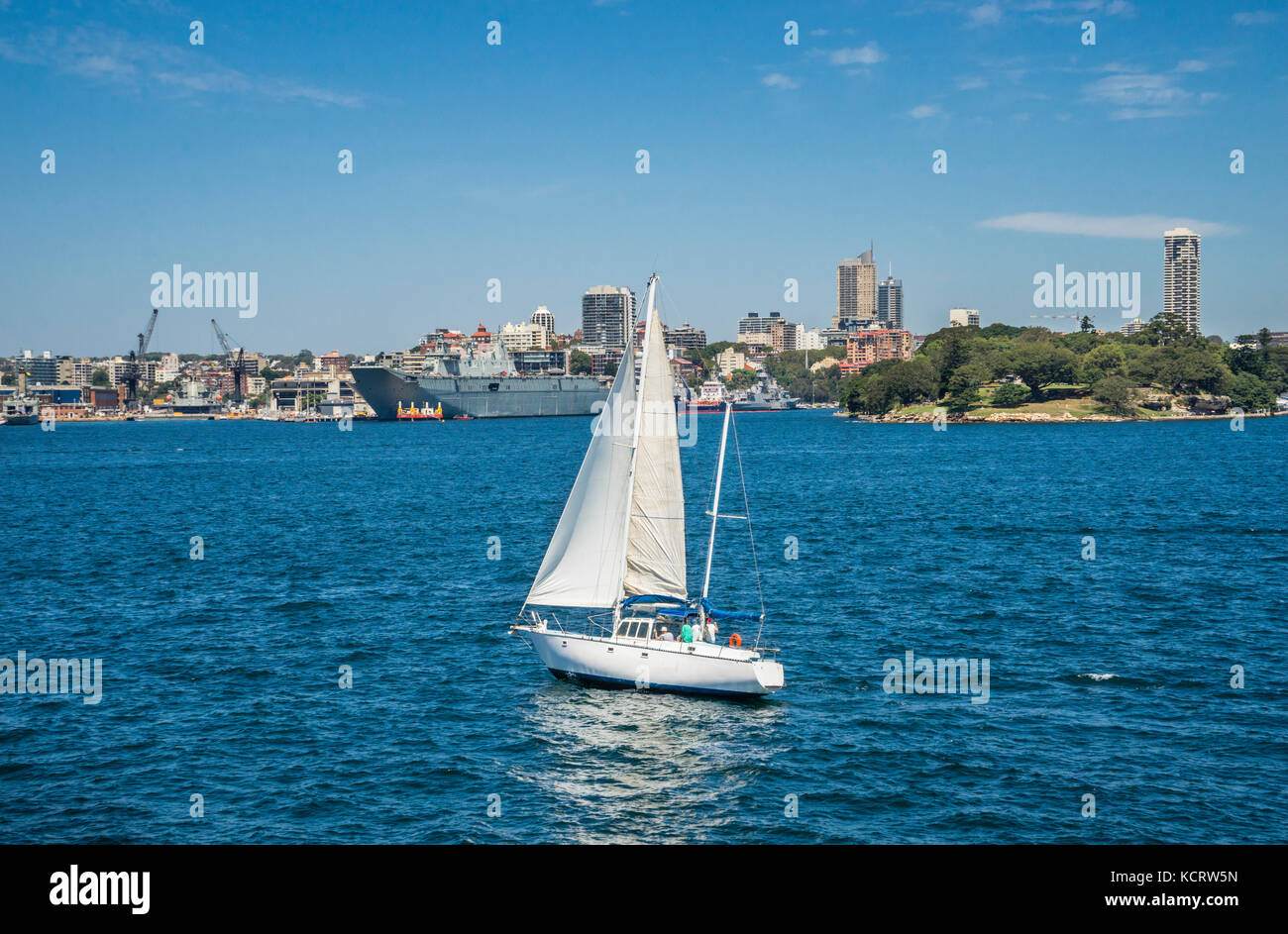 Australia, Nuovo Galles del Sud, Port Jackson, vela Sydney Harbour contro lo sfondo dell'Isola Giardino navale cantiere di Dock e la onorevole Maquaries punto Foto Stock
