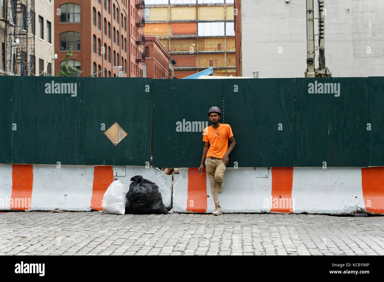 Un lavoratore edile di fumare una sigaretta durante una pausa dal suo lavoro su Desbrosses San di Tribeca, un quartiere di Lower Manhattan, New York City. Foto Stock