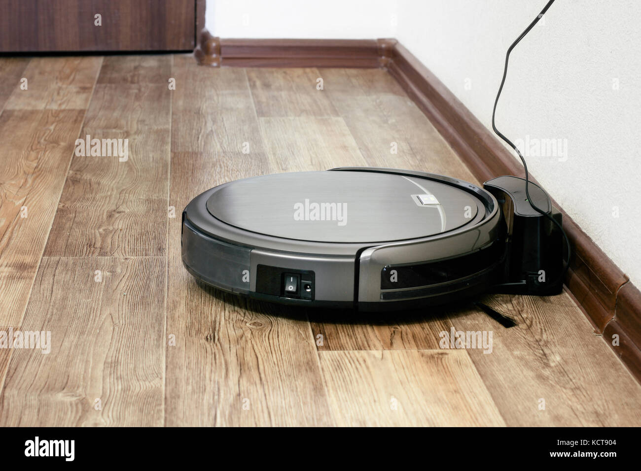 Robot aspirapolvere sul pavimento in parquet Foto stock - Alamy