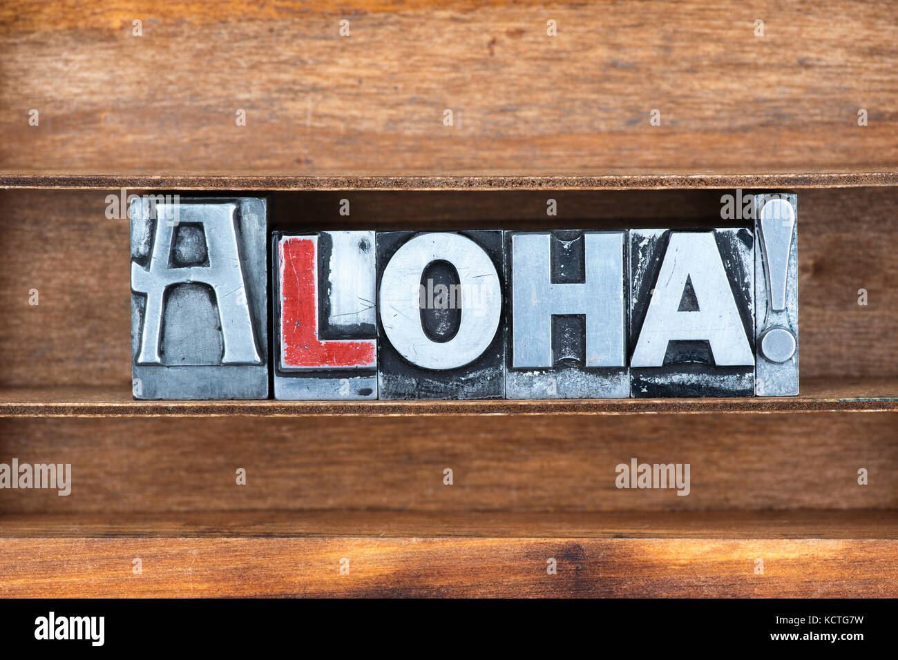 Aloha - saluto hawaiano esclamazione realizzato da metallico tipo di stampa in rilievo sul vassoio in legno Foto Stock