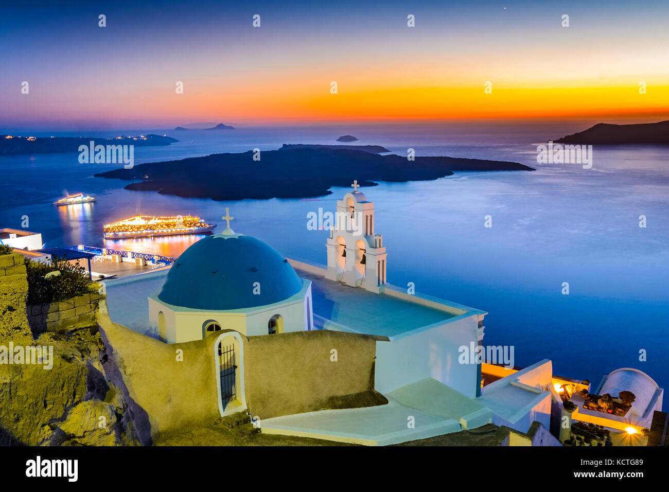Firostefani, Santorini, Grecia. twilight con la vecchia chiesa greca e caldera a mare Egeo - isole greche - punto di riferimento Foto Stock