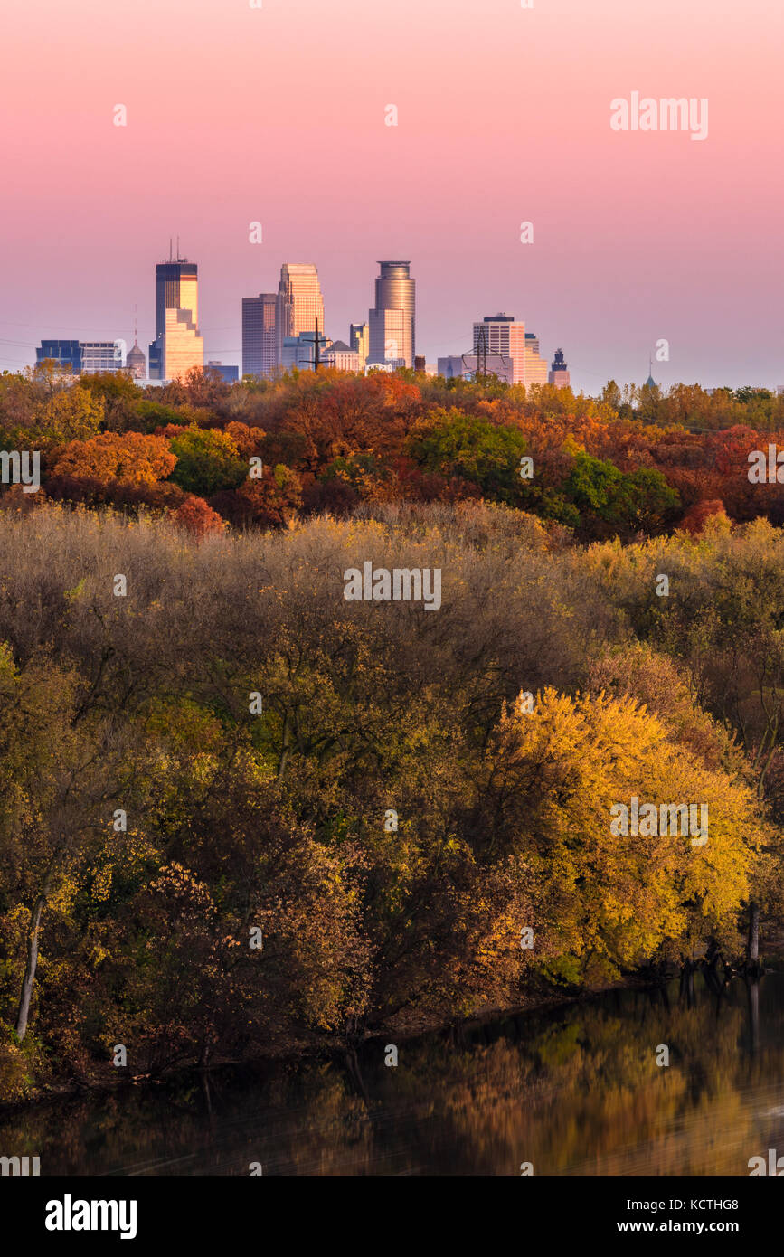 Colore di autunno lungo il fiume Mississippi con il Minneapolis skyline di distanza a sunrise. Foto Stock