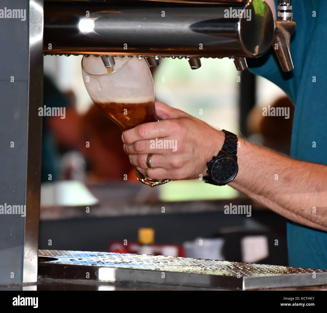 Il barista in un bar informale di colata e la miscelazione di bevande e liquori Foto Stock