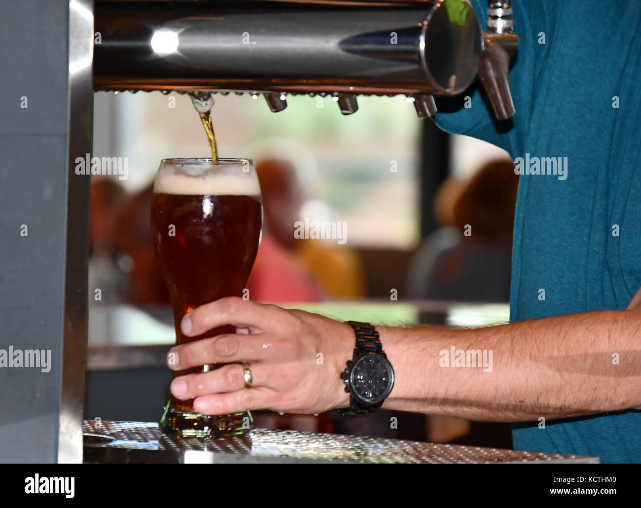 Il barista in un bar informale di colata e la miscelazione di bevande e liquori Foto Stock