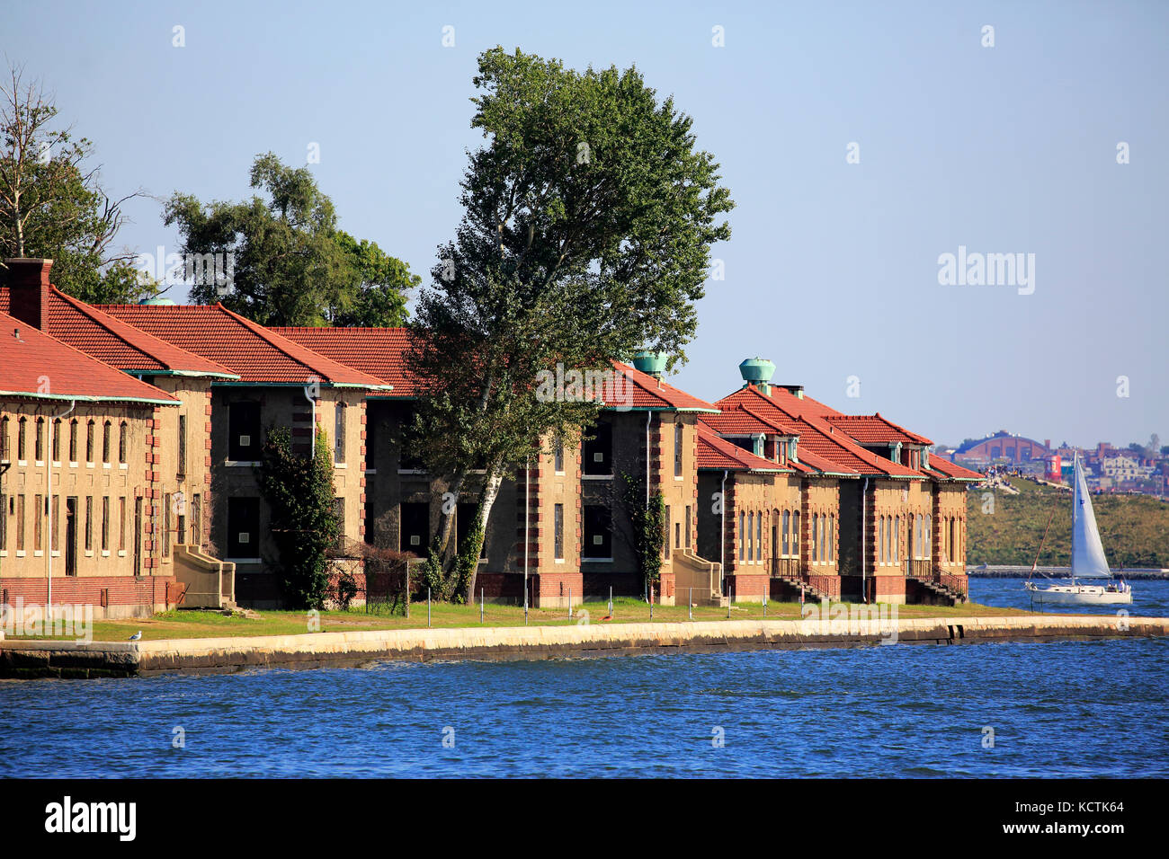 Una barca a vela passando per lo storico Ellis Island immigrant Hospital.Jersey City.New Jersey.USA Foto Stock