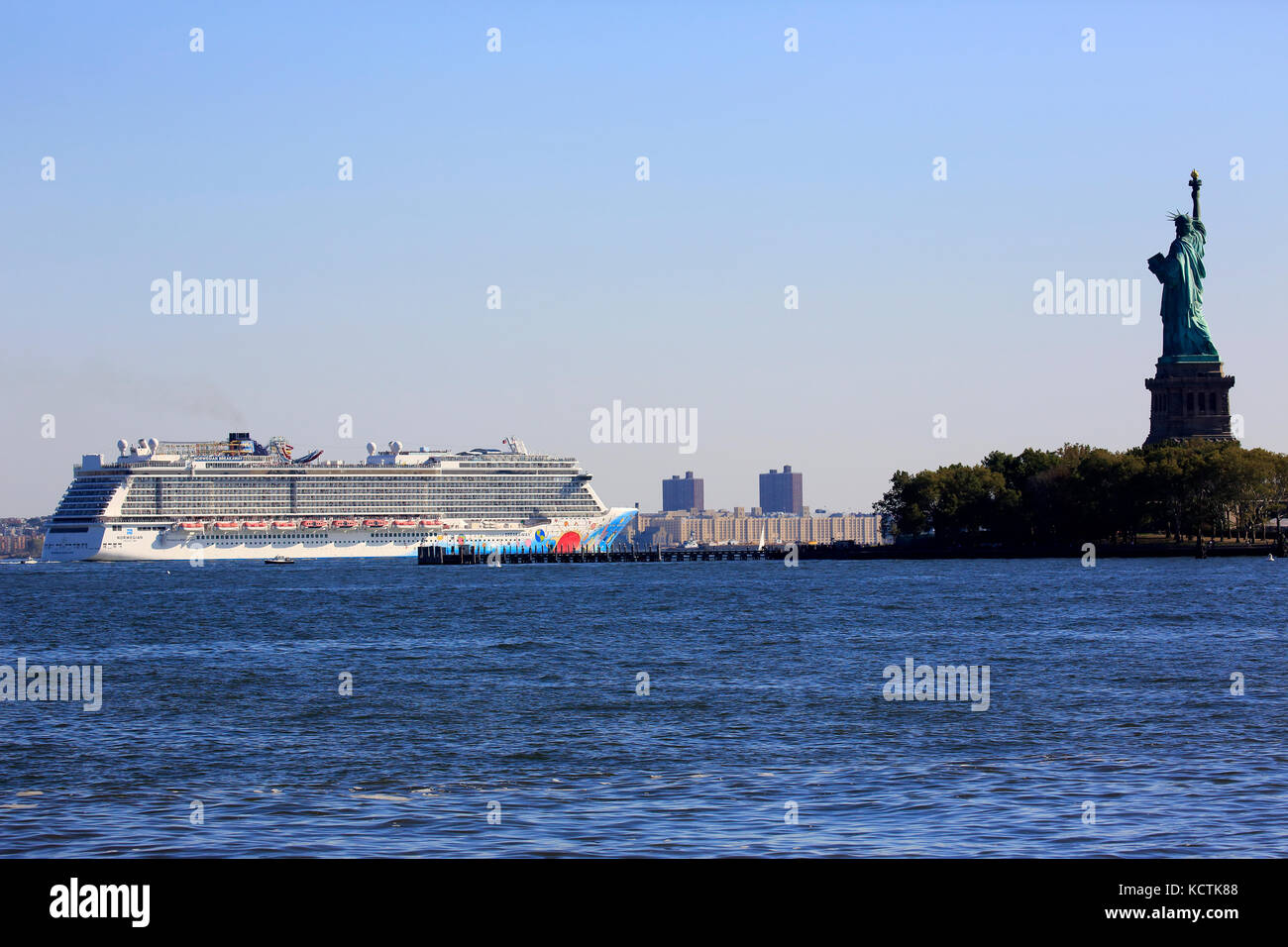 Norwegian Breakaway nave da crociera passando Liberty Island con la Statua della Libertà accanto nel porto di New York. New York City.New Jersey.USA Foto Stock