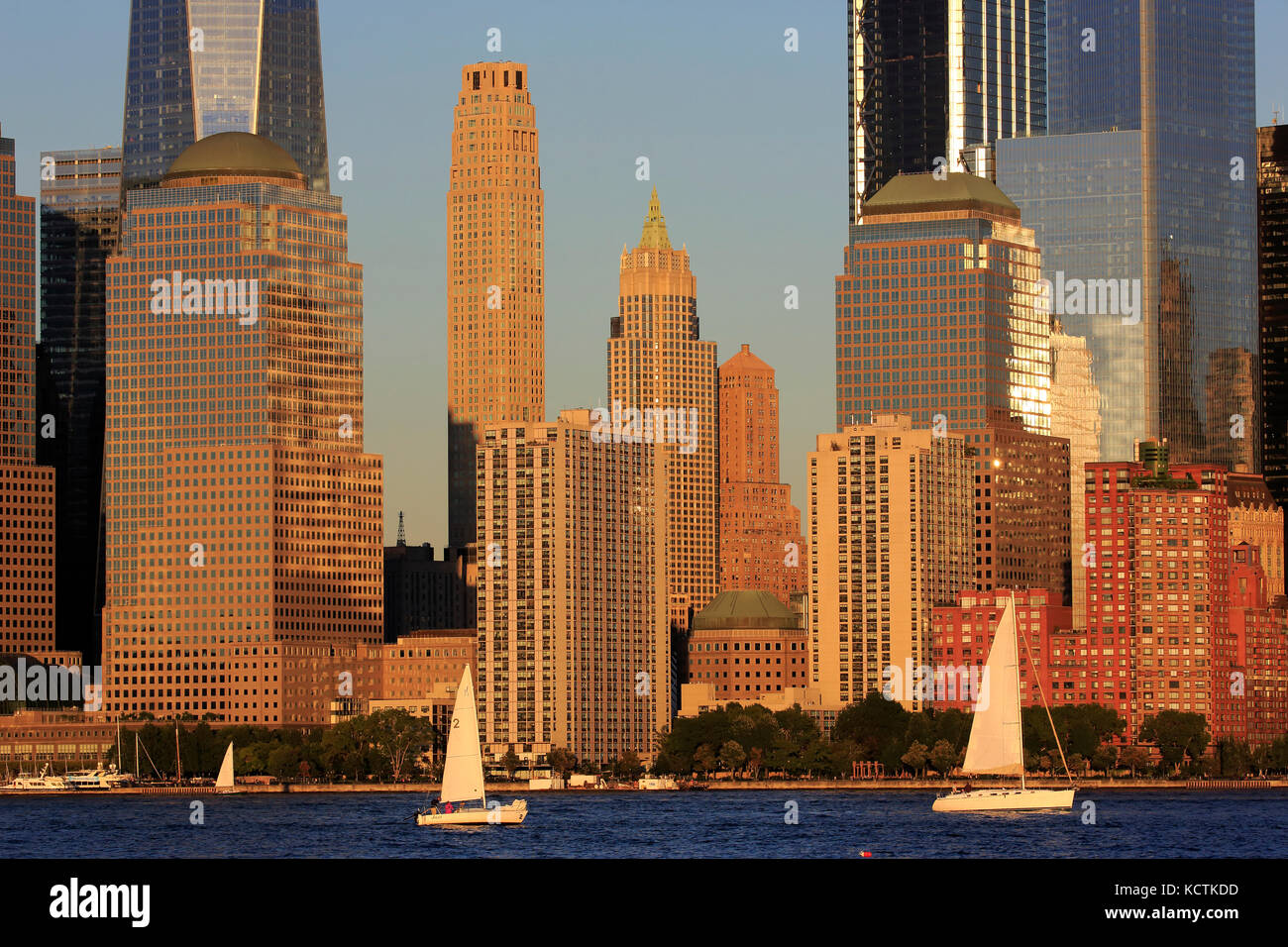 Skyline del quartiere finanziario di Lower Manhattan con barche a vela nel fiume Hudson in primo piano sotto la luce del sole del tardo pomeriggio.New York City.USA Foto Stock