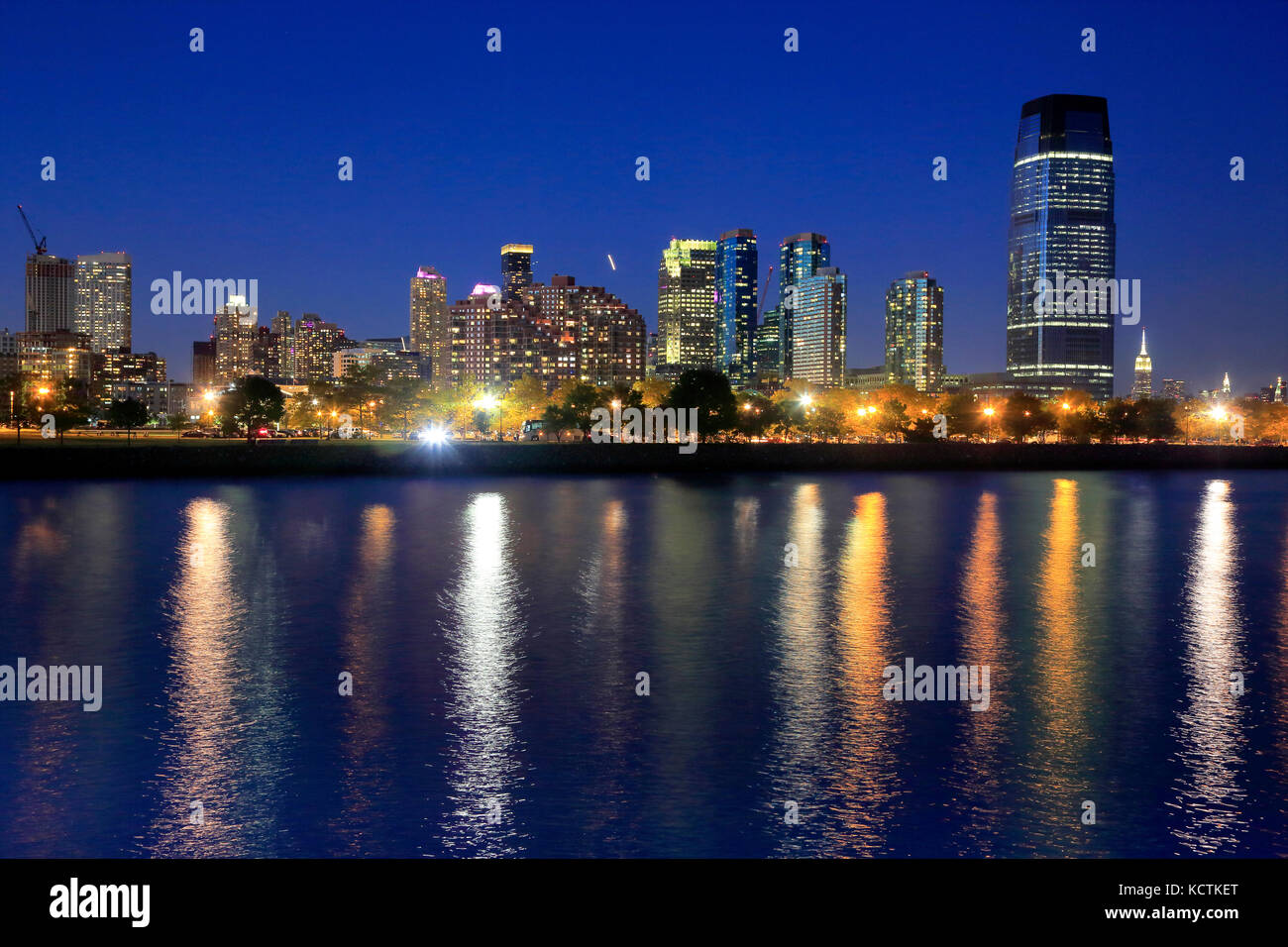 Vista notturna dello skyline di Jersey City con la Goldman Sachs & Co Tower e lo skyline di Manhattan sullo sfondo. New Jersey.USA Foto Stock