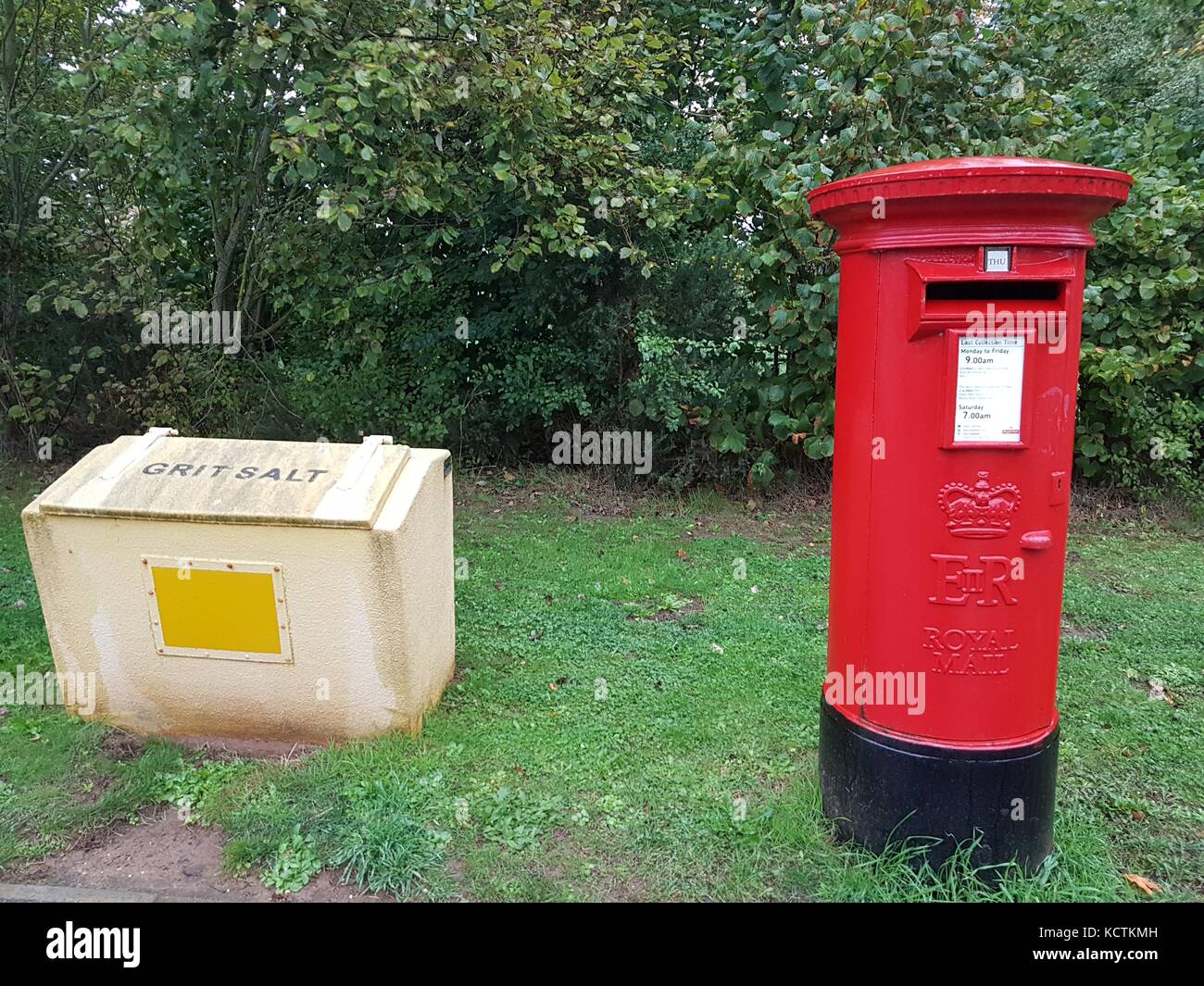 Un rosso royal mail pilastro casella accanto ad un giallo sale grana bin in Inghilterra, ottobre 2017 Foto Stock