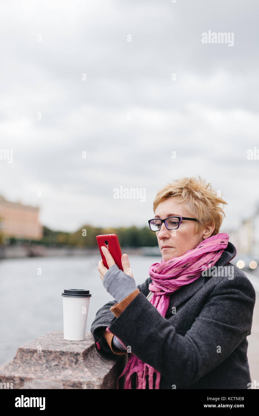 Donna con telefono sulla spianata Foto Stock