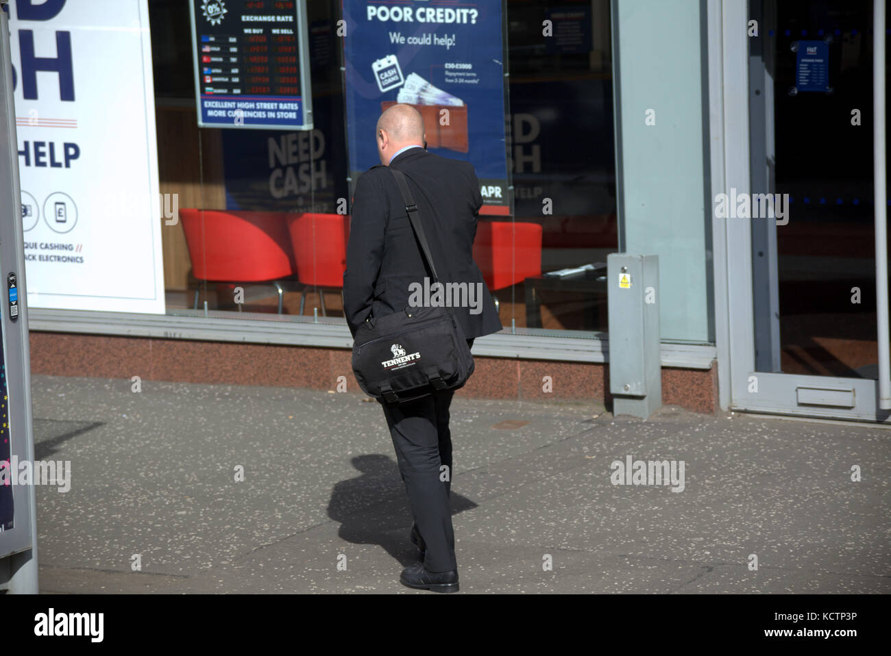 Poveri di credito Uomo al telefono con la sacca sulla strada a piedi in stile business visto da dietro Foto Stock
