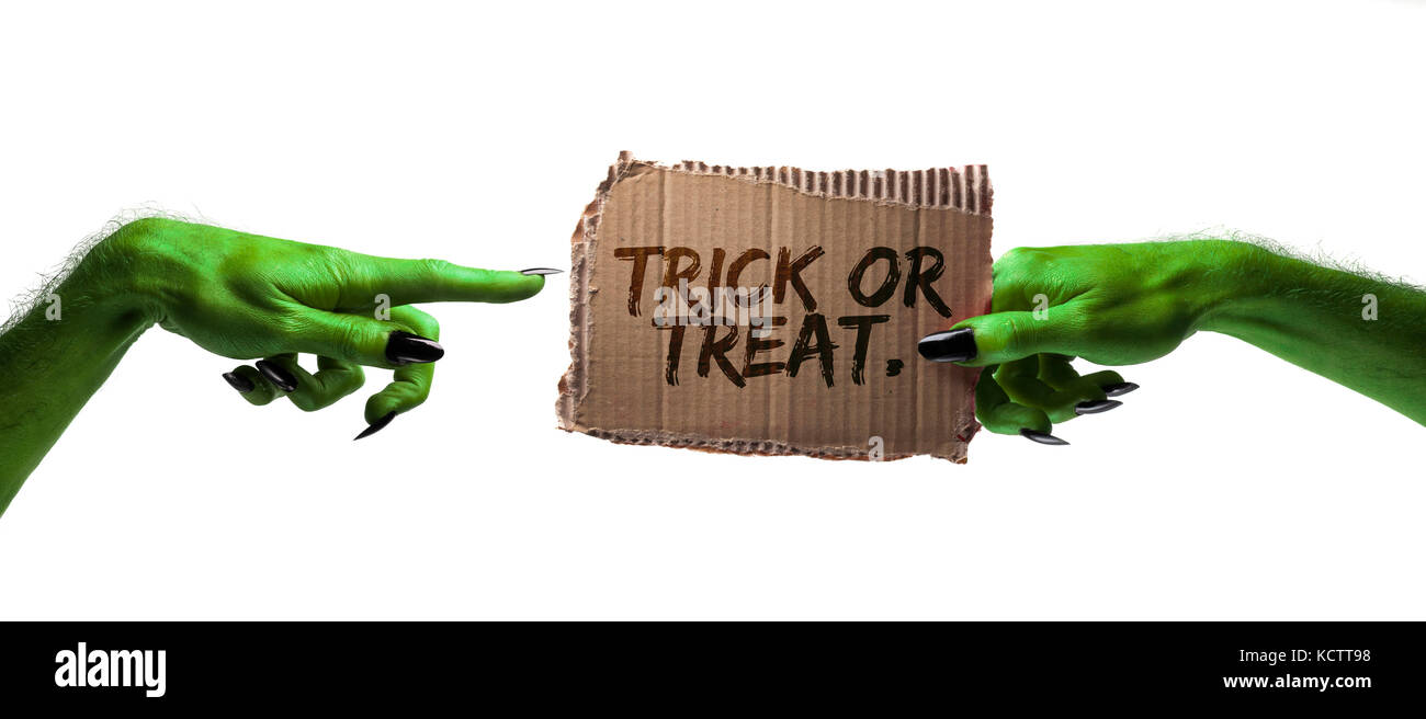 Dolcetto o scherzetto. verde streghe o zombie monster mano che tiene una scheda di halloween segno Foto Stock