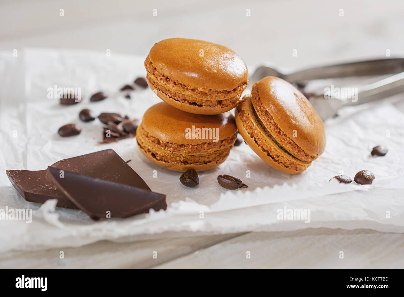 Pezzi di cioccolato sciolto con i chicchi di caffè e caffè aromatizzati macarons presentati su un tovagliolo bianco Foto Stock