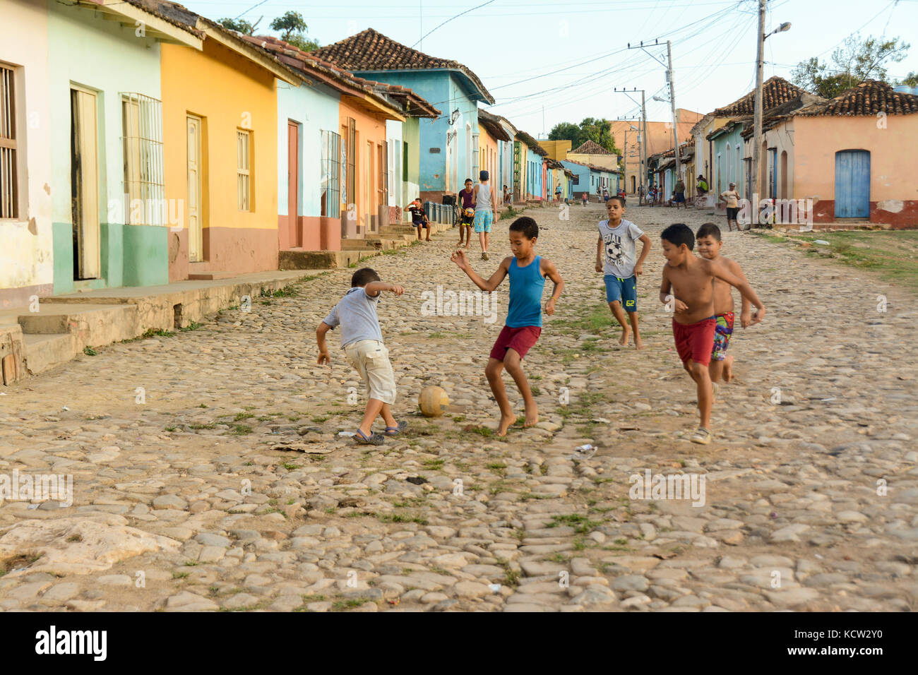 Ragazzi giocare a calcio da una fila di case colorate, Trinidad, Cuba Foto Stock
