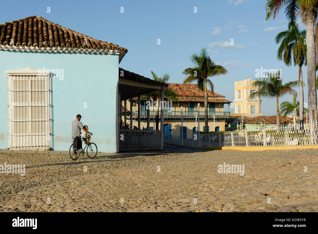 L'uomo spinge il ragazzo sulla bicicletta, Plaza de Mayor, Trinidad, Cuba Foto Stock