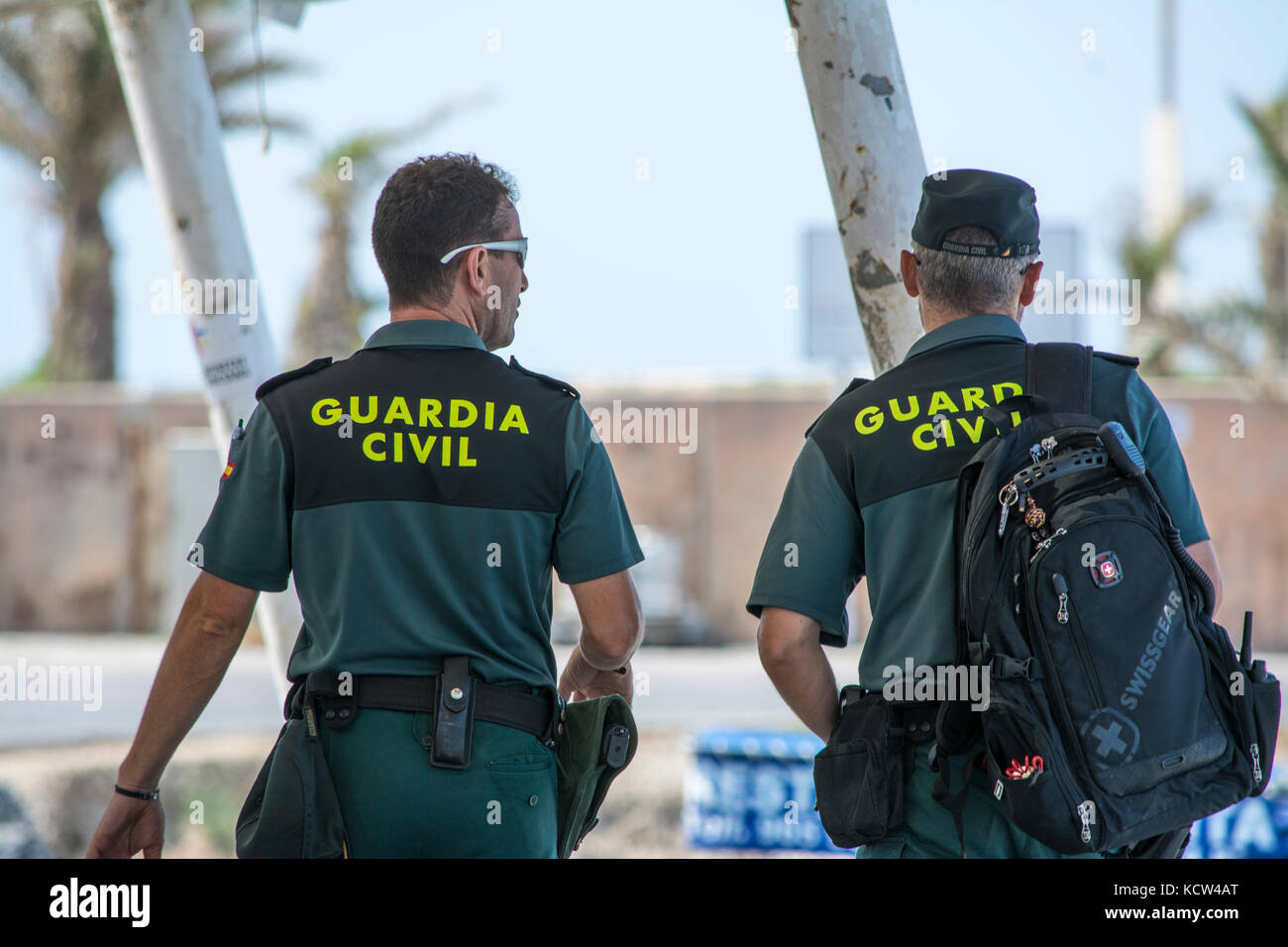 Due Guardia civile spagnola (Guardia civile) ufficiali pattugliano il porto sull'isola spagnola di Tabarca Foto Stock