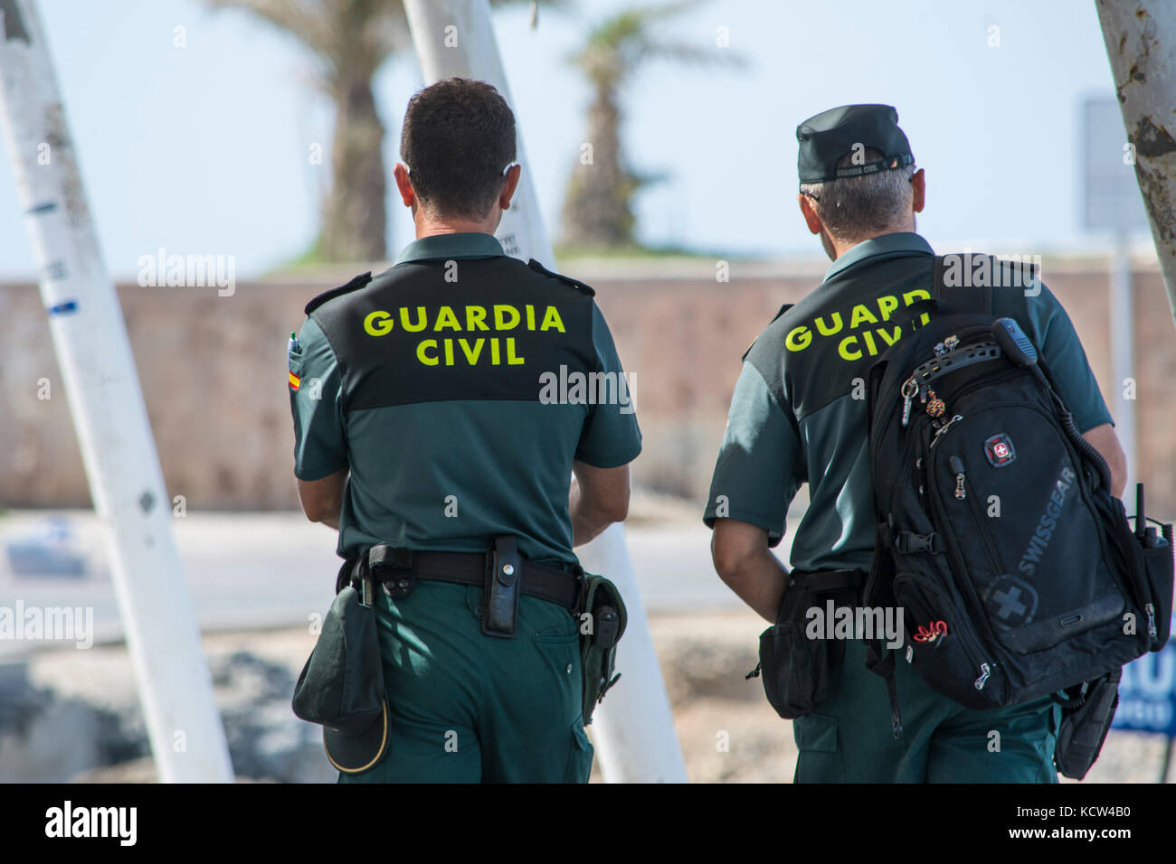 Due Guardia civile spagnola (Guardia civile) ufficiali pattugliano il porto sull'isola spagnola di Tabarca Foto Stock