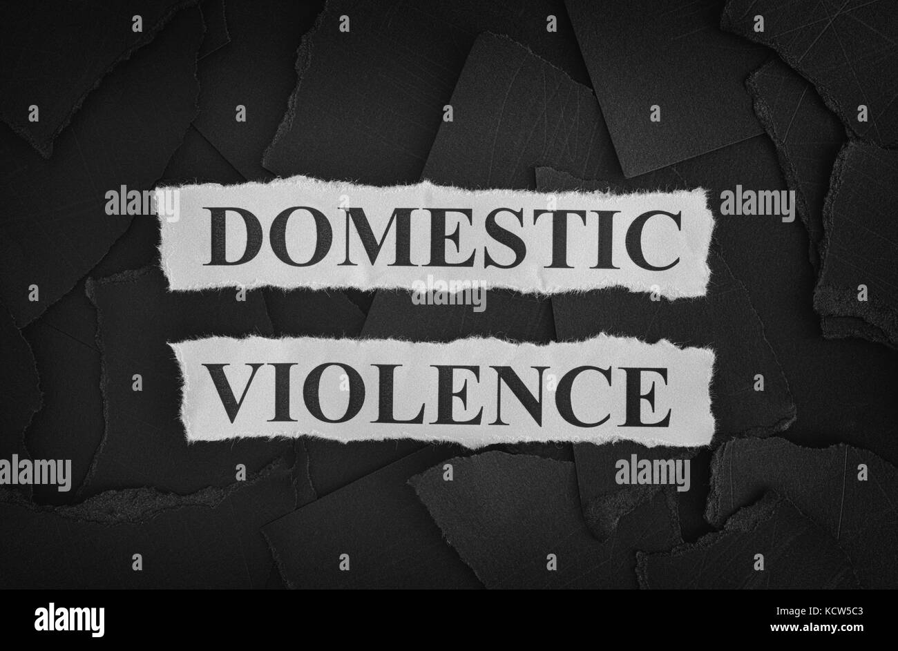 Frammenti di carta nera e le parole di violenza domestica. Concetto di immagine. in bianco e nero. primo piano. Foto Stock