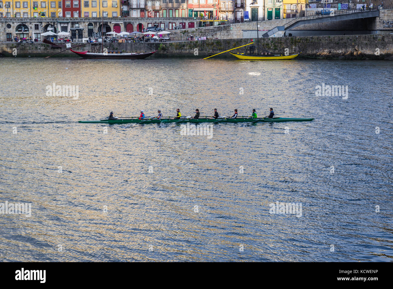 Vogatori in un otto coxed, una barca a remi spazzata sul fiume Douro visto dalla città di Vila Nova de Gaia, Portogallo. Città di Porto sullo sfondo Foto Stock