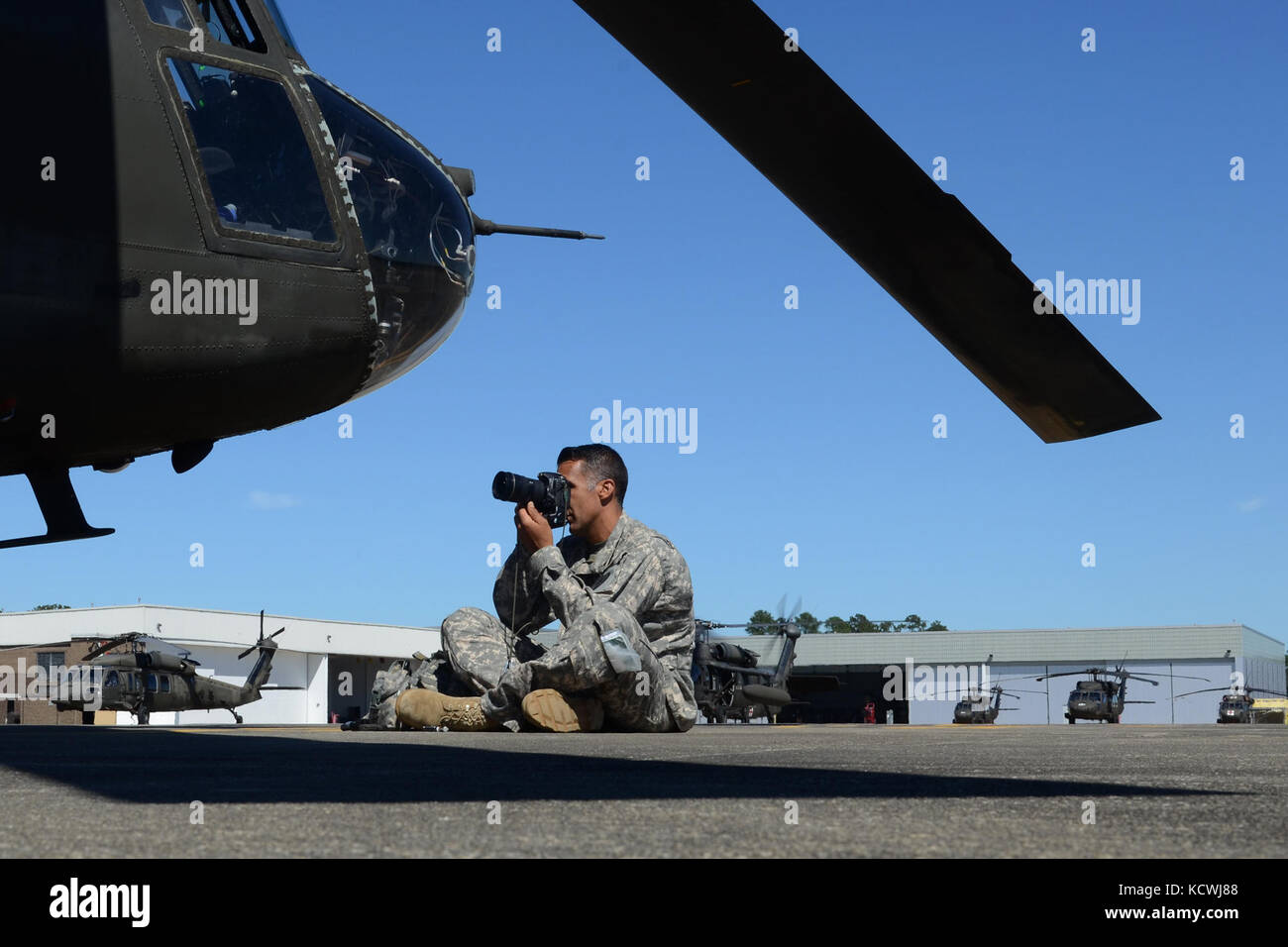 Us army staff sgt. roberto di giovine, cameraman di combattimento e storico per la Carolina del Sud la guardia nazionale, fotografie un scng ch-47f chinook, un pesante-lift elicottero configurato con una gamma estesa del sistema di alimentazione del carburante (erfs), a cui si fa riferimento anche come "vacca grassa", e il suo equipaggio assegnati a distacco 1, l'azienda b, 2-238th supporto generale del battaglione di aviazione, 59th aviazione il comando delle truppe da greenville s.c., oct. 10, 2016. ch-47f e il suo equipaggio sono messa in scena la loro base di operazioni a sostegno dell'uragano matteo gli sforzi di recupero a mcentire comune di Guardia nazionale base, eastover, s.c. ap Foto Stock