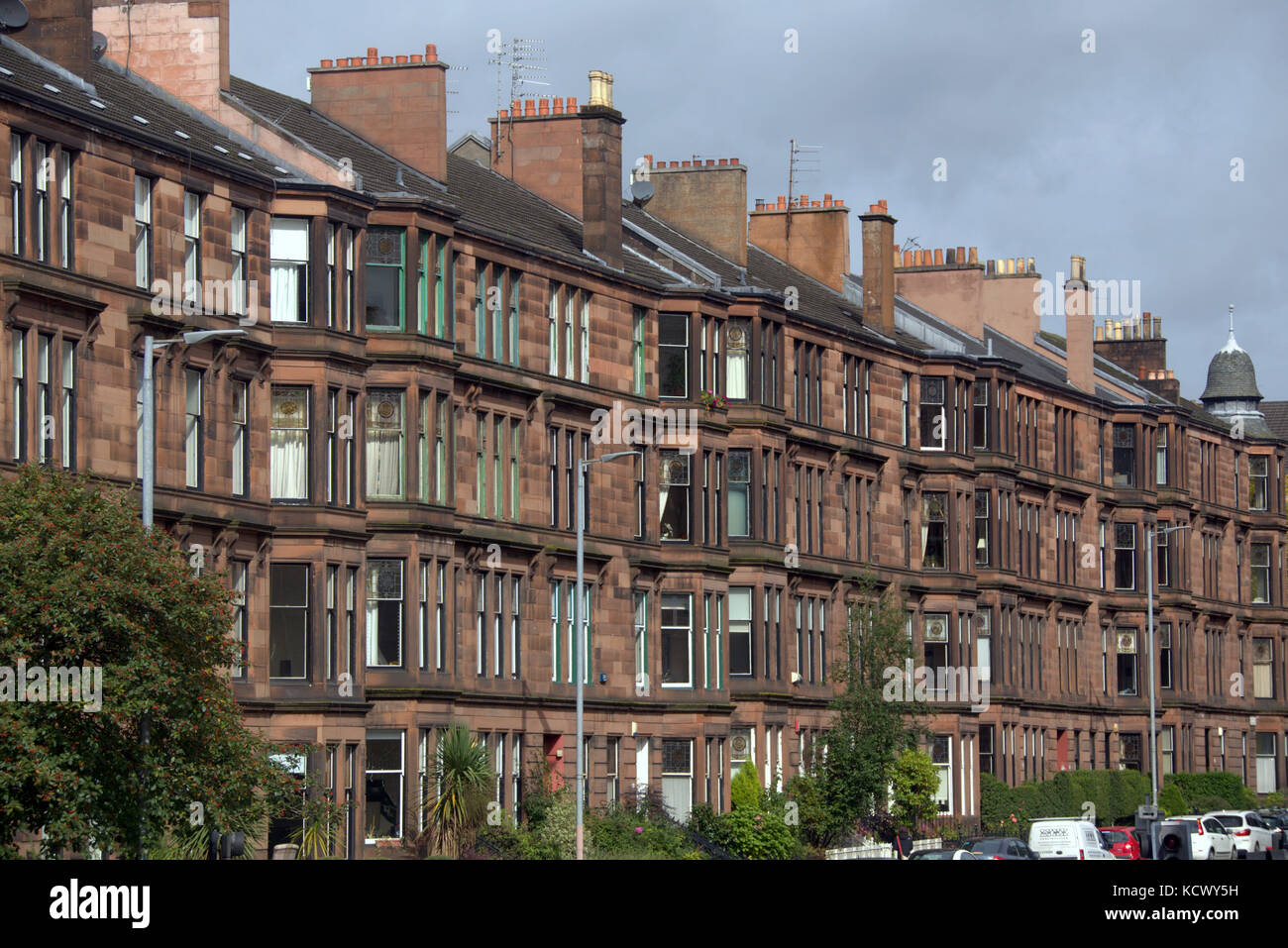 Guida in collina a Glasgow abitazioni in pietra arenaria rossa Foto Stock