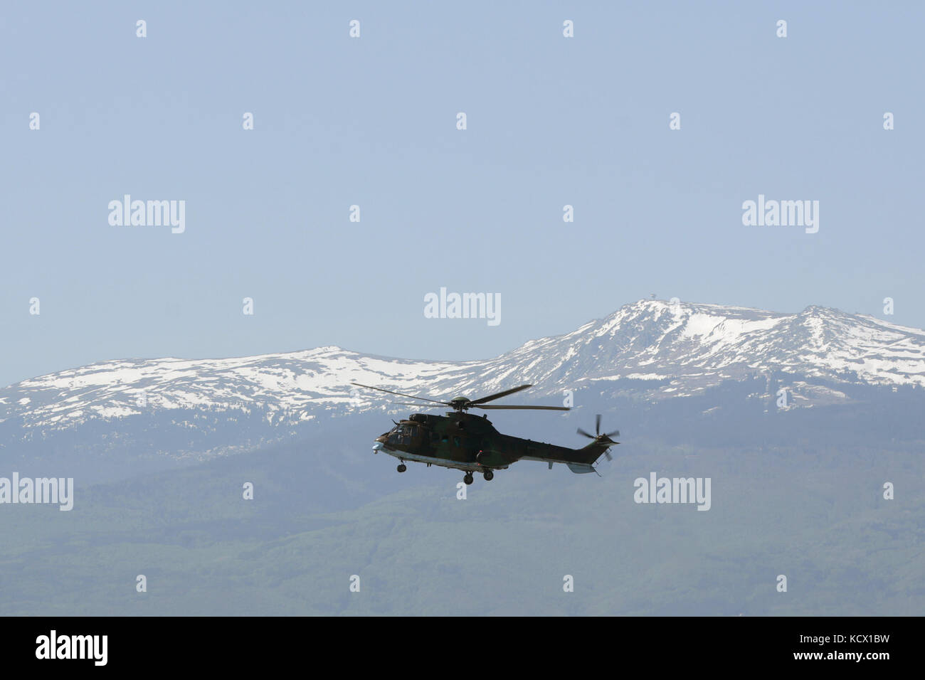 Elicottero militare di fronte alla catena montuosa. Foto Stock