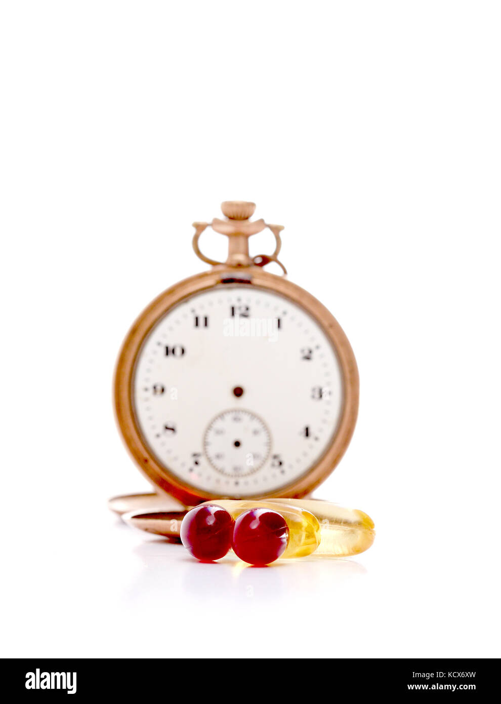 Immagine di un olio di fegato di merluzzo omega 3 e olio di krill capsule di gel nella parte anteriore del vintage orologio da tasca Foto Stock