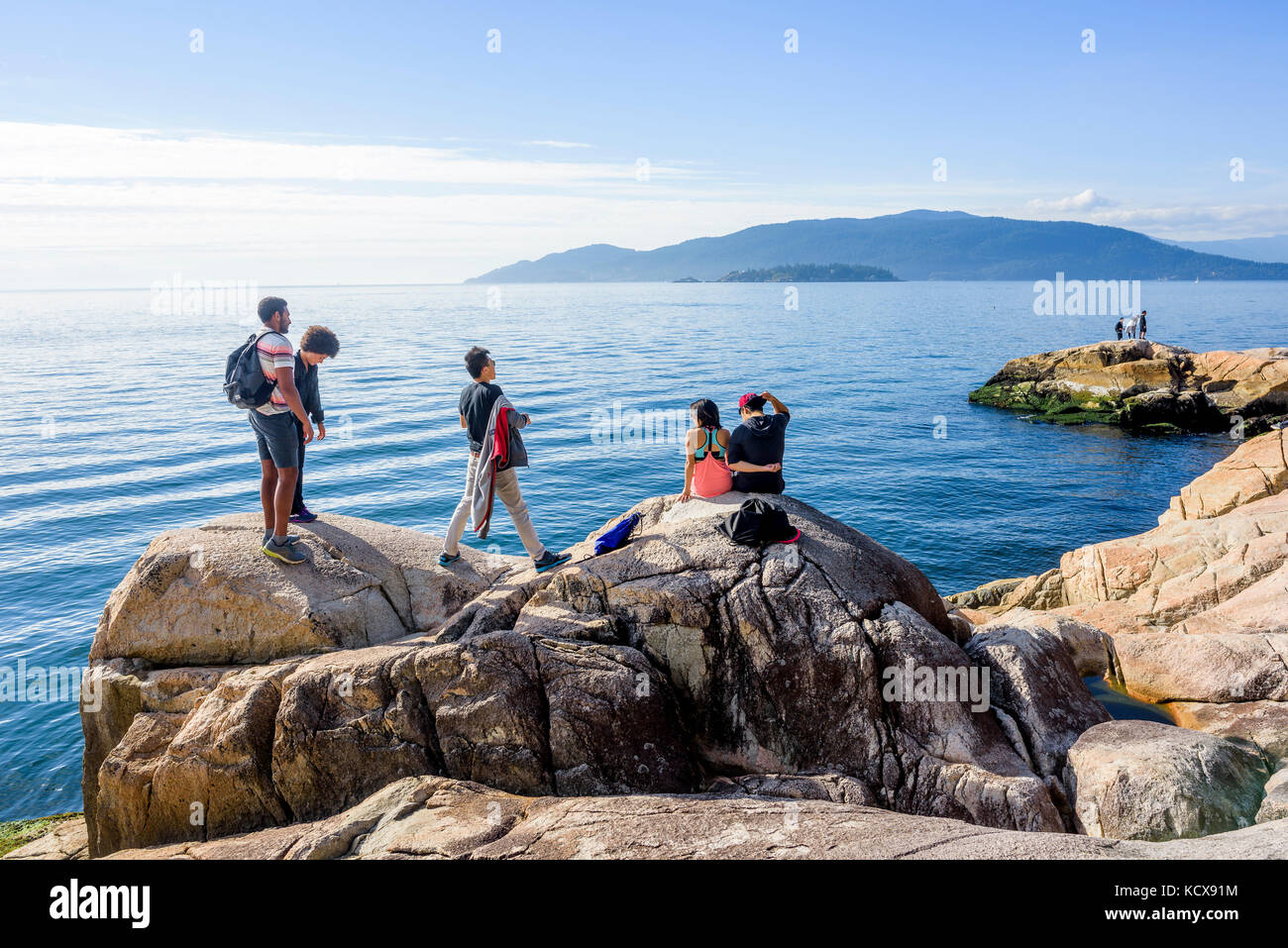 Gli escursionisti sulla battigia rocce nel Parco del faro, West Vancouver, British Columbia, Canada. Foto Stock
