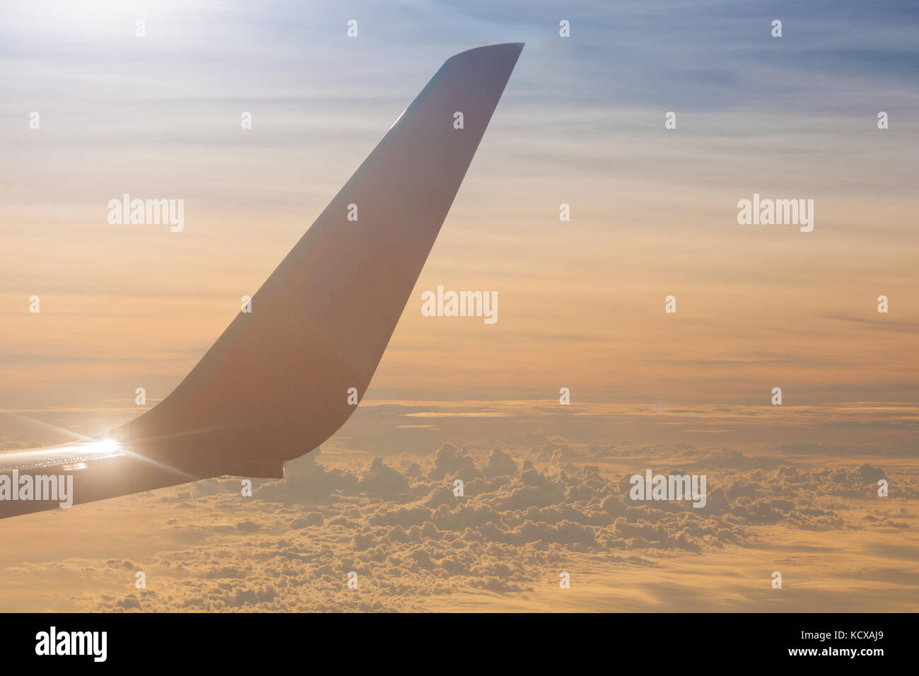 Ala di aeroplano che vola sopra le nuvole in mattina. Foto Stock