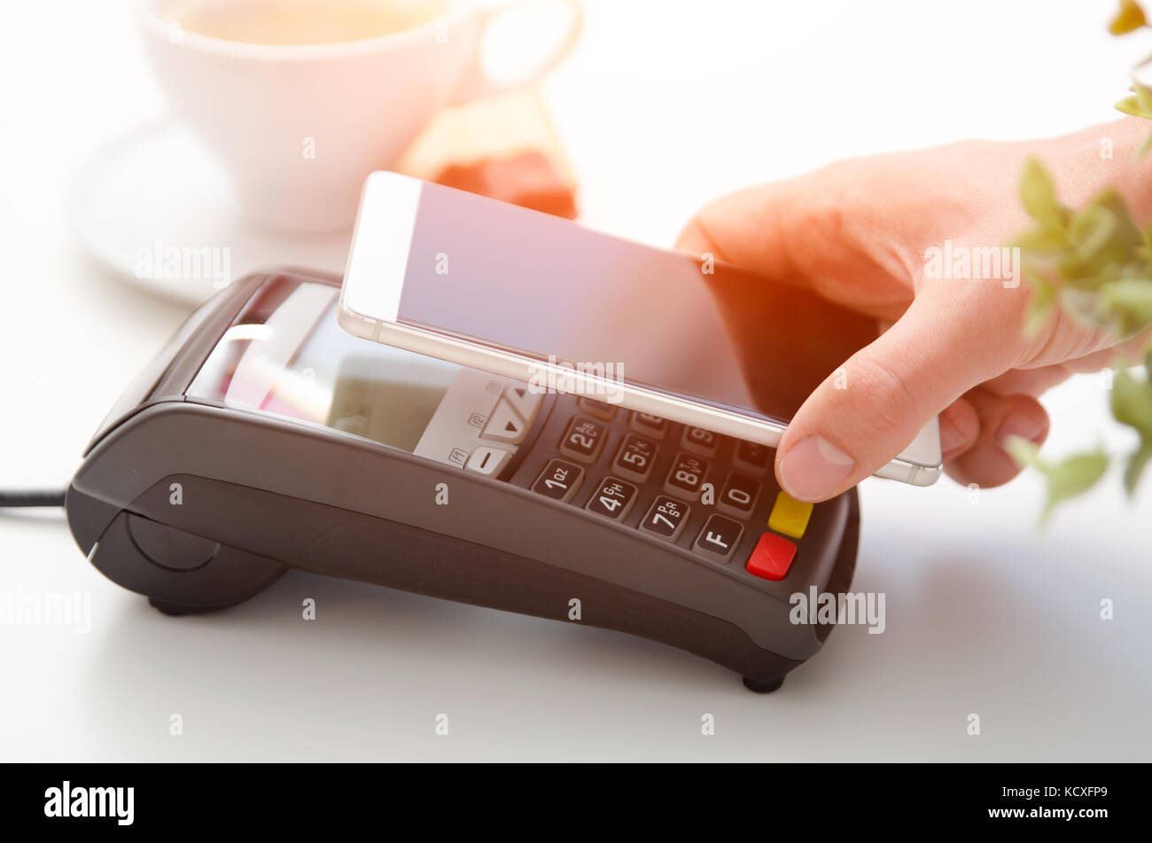 Pagamento mobile in cafe con smart phone nfc near field communication la tecnologia wireless Foto Stock