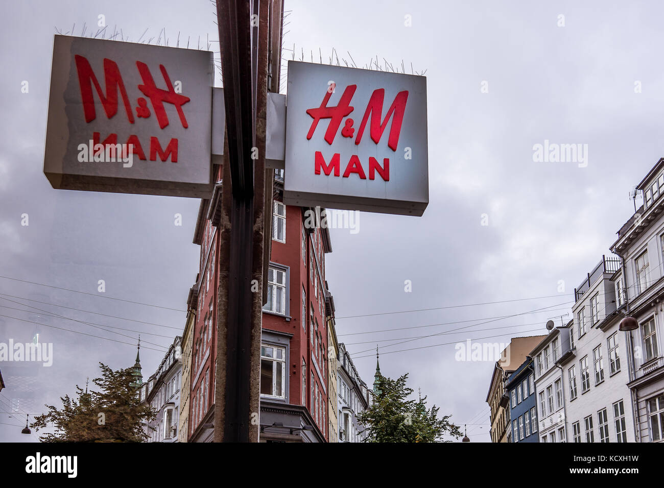 Hm uomo segno riflessioni in una vetrina di un negozio, contro il cielo blu, Copenaghen, Danimarca, 21 settembre 2017 Foto Stock