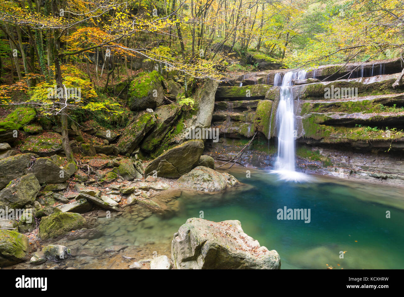 Cascata in un bosco con i colori autunnali in italia Foto Stock