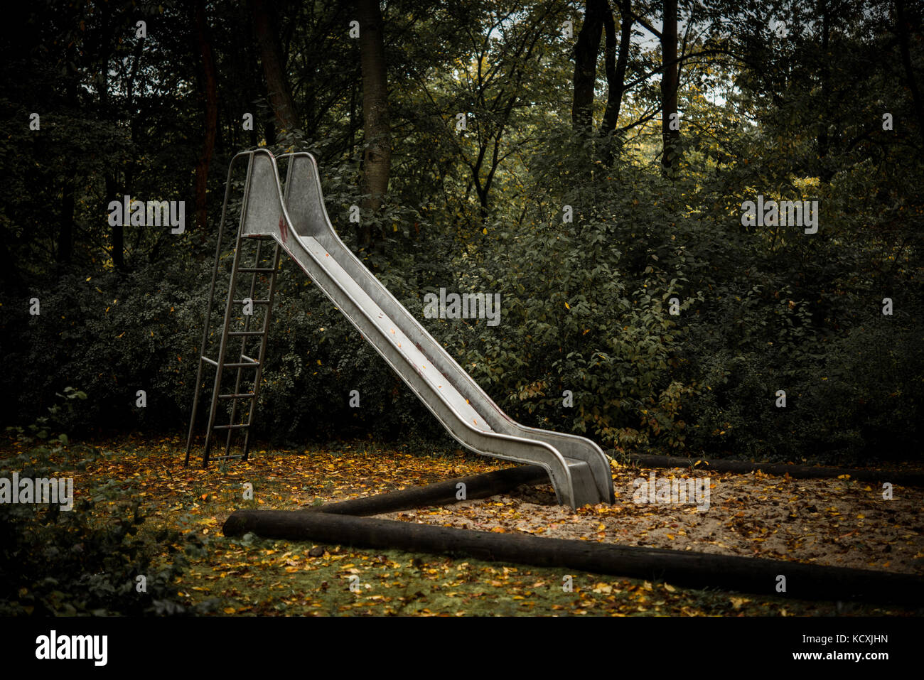 Vecchio abbandonato il parco giochi con scivolo in autunno Foto Stock